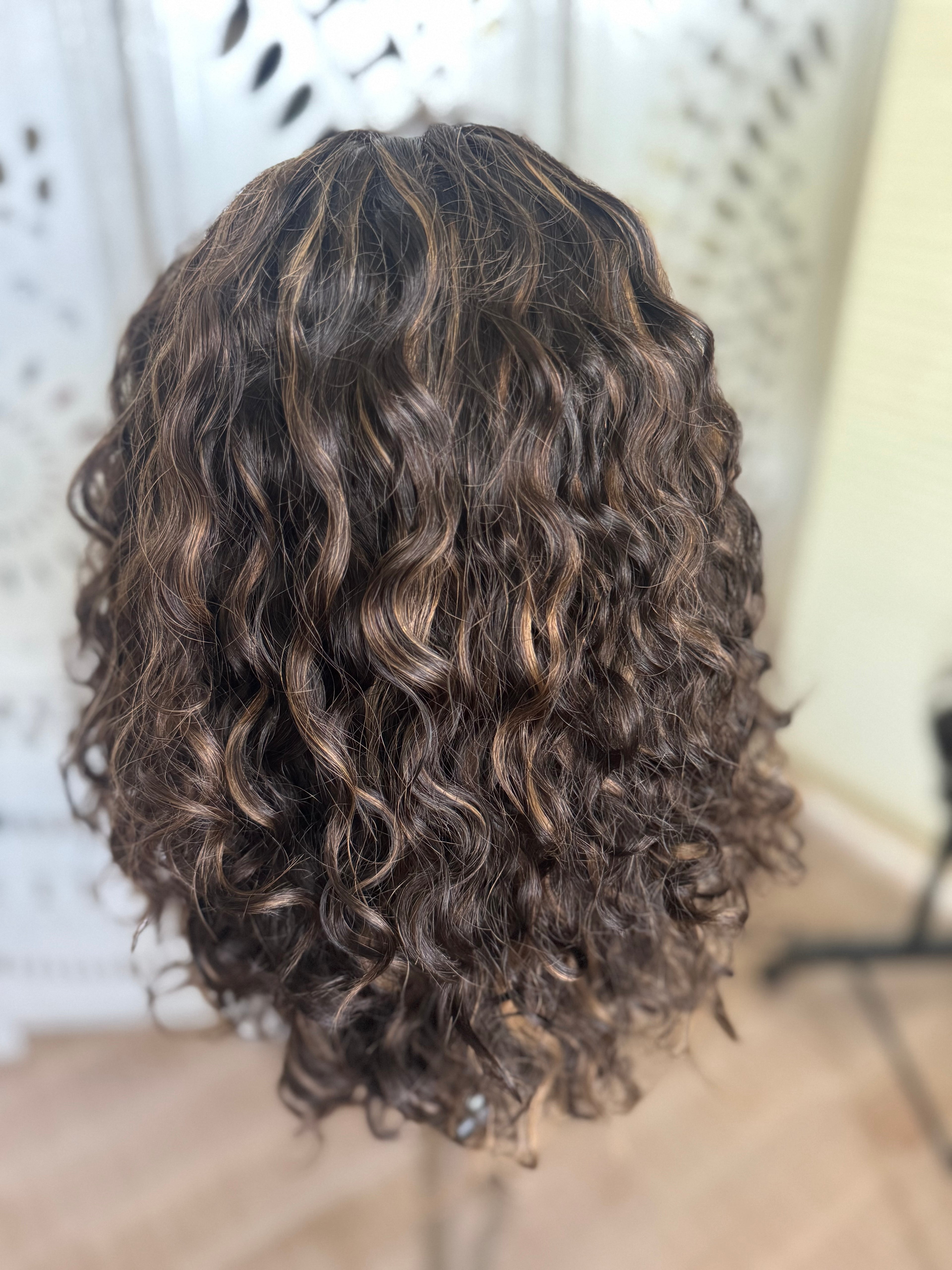 Curly wig styled in a way that highlights its texture and volume.