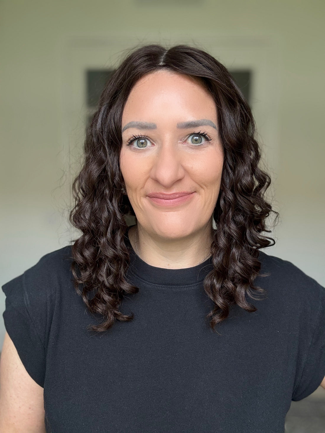 woman wearing curly human hair topper. curly hair topper. realistic curly hair topper